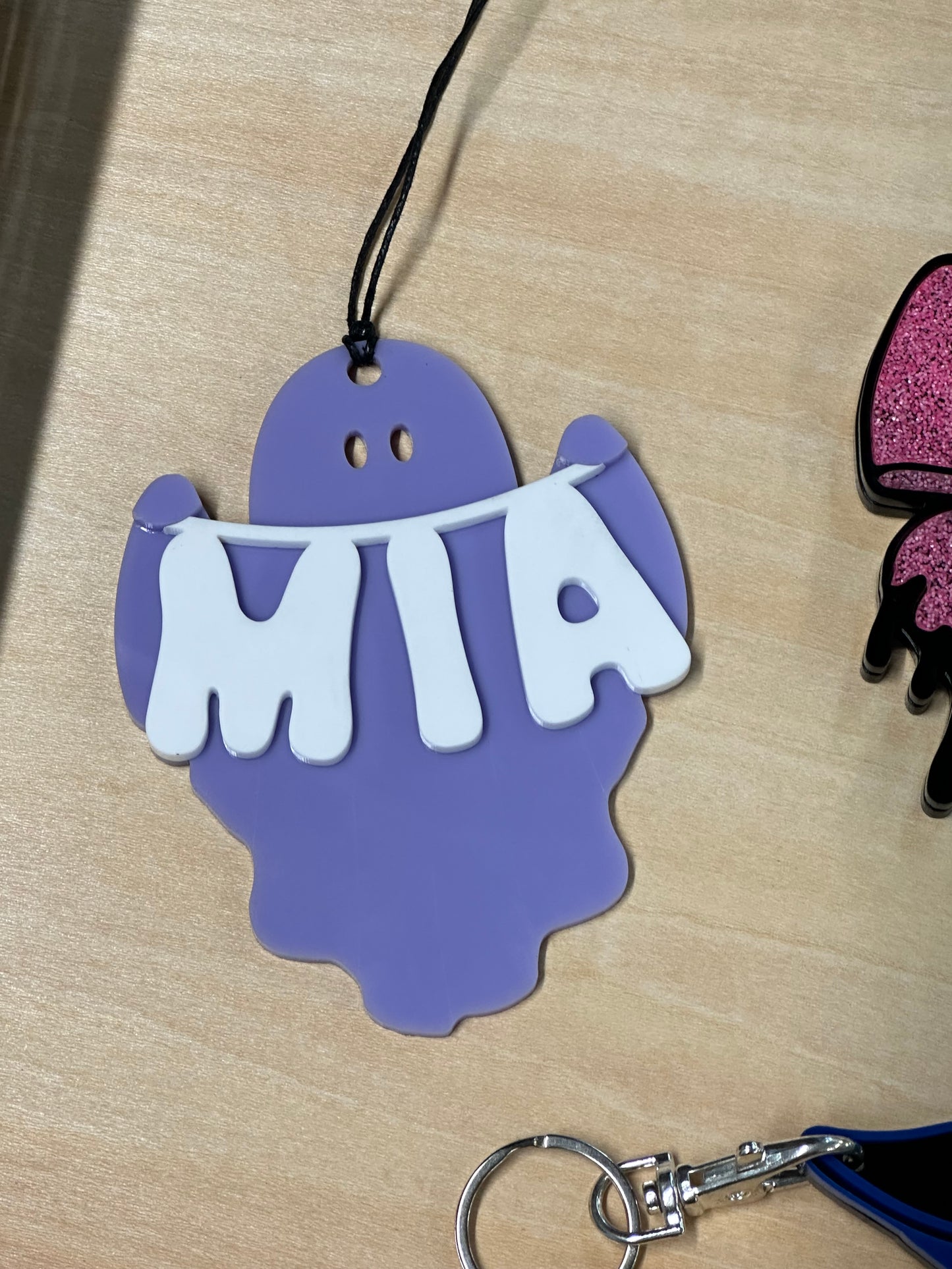 Ghost holding name banner tag
