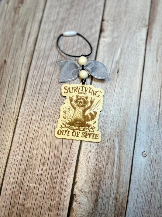 Surviving purely out of spite raccoon car charm